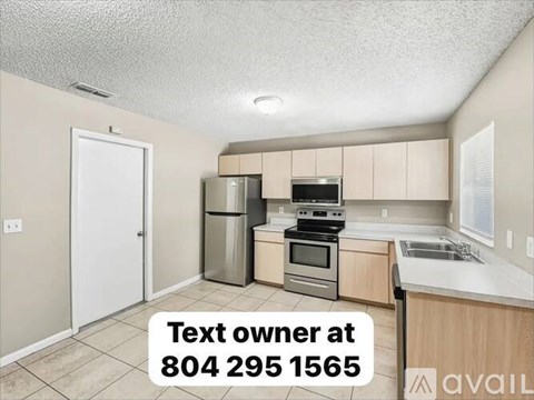 A kitchen with a text overlay asking to contact the owner at a provided phone number.