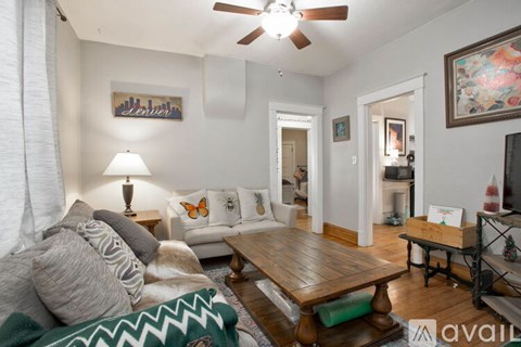 A living room with a couch, a coffee table, and a painting on the wall.