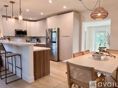 A modern kitchen with a bar area and a dining table set for four.