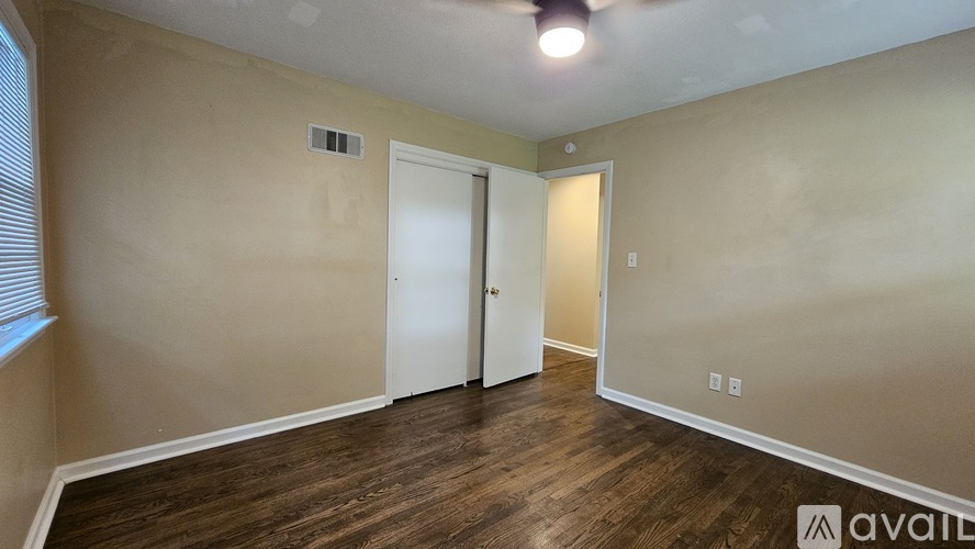 A room with wooden floors and two doors.