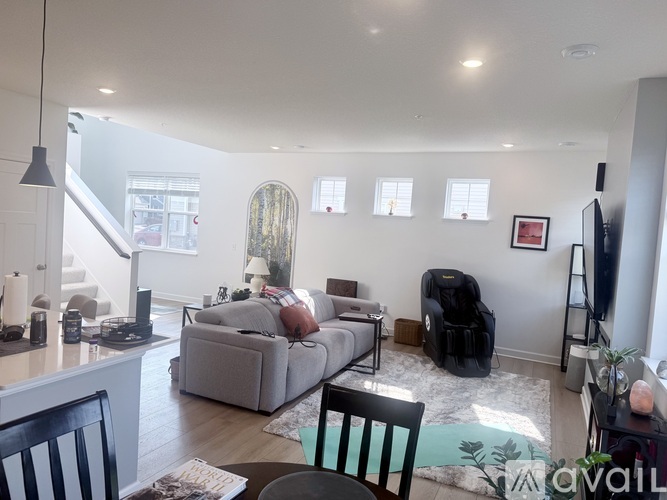 A living room with a grey couch and a black chair.