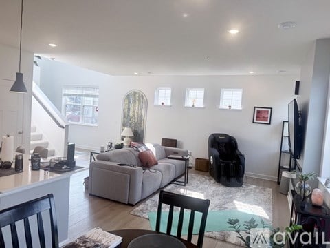 A living room with a grey couch and a black chair.