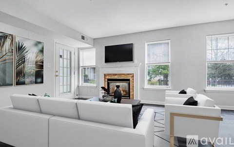 A living room with a white couch and a fireplace.