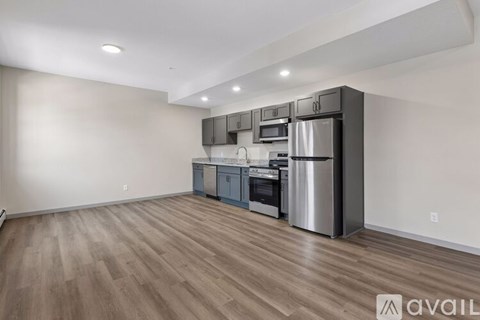 A kitchen with stainless steel appliances and wooden flooring.