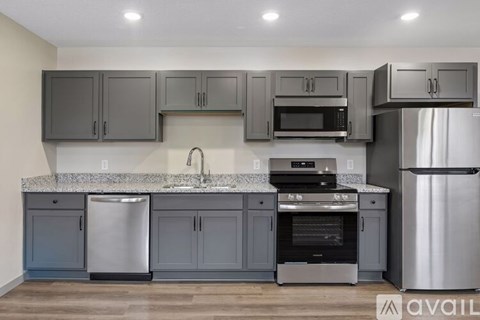 A kitchen with grey cabinets and stainless steel appliances.