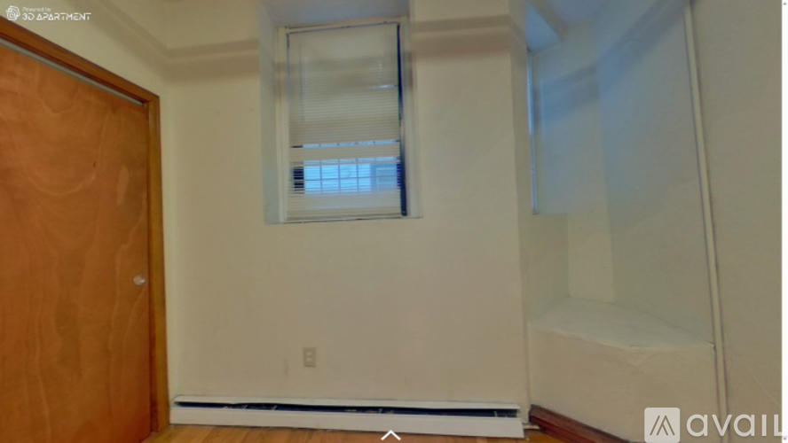 A room with a wooden door and a window with blinds.
