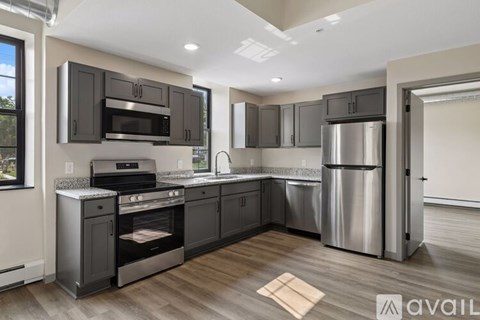 A modern kitchen with dark wood cabinets and stainless steel appliances.