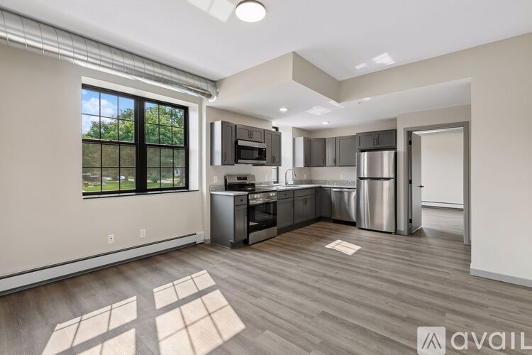 A modern kitchen with stainless steel appliances and a large window.