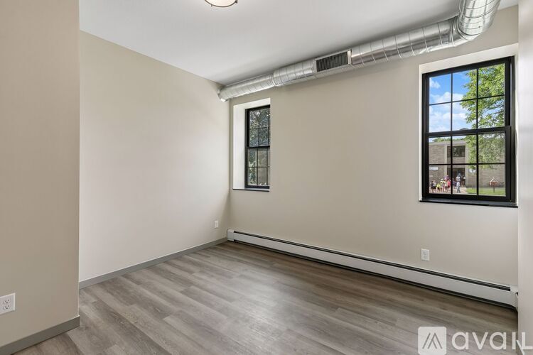 A room with a window and a wall-mounted air conditioner.