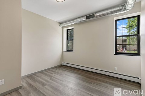 A room with a window and a wall-mounted air conditioner.