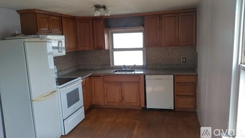 A kitchen with wooden cabinets and white appliances.