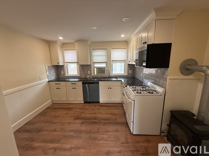 A kitchen with wooden floors and white appliances.