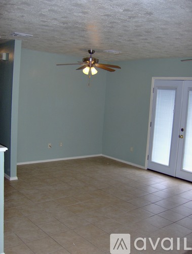 A room with a ceiling fan and tile flooring.