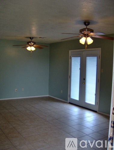 A room with a ceiling fan and a door.