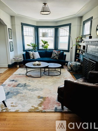 A living room with a blue couch and a rug.