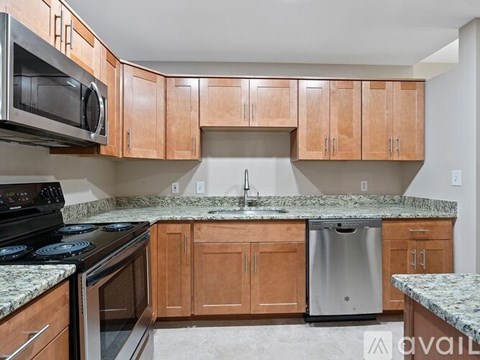 A kitchen with wooden cabinets and granite countertops.