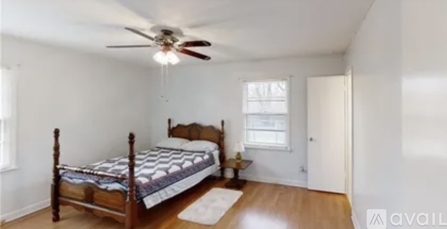 A bedroom with a bed, a ceiling fan, and a rug.