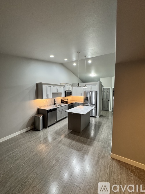 A modern kitchen with a large island and stainless steel appliances.