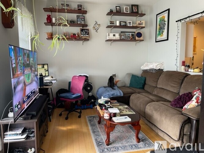 A living room with a couch, a chair, a coffee table, and a television.