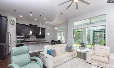 A modern living room with a white couch and a light blue chair.