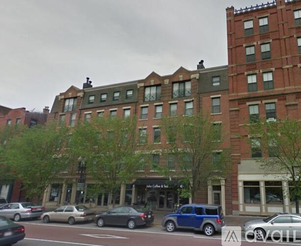 A street view of a building with cars parked in front.
