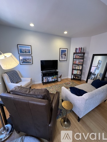 A living room with a brown leather chair and a white sofa.