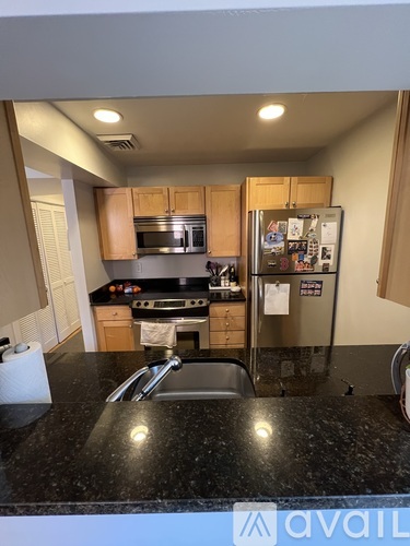 A kitchen with granite countertops and a refrigerator with magnets on it.