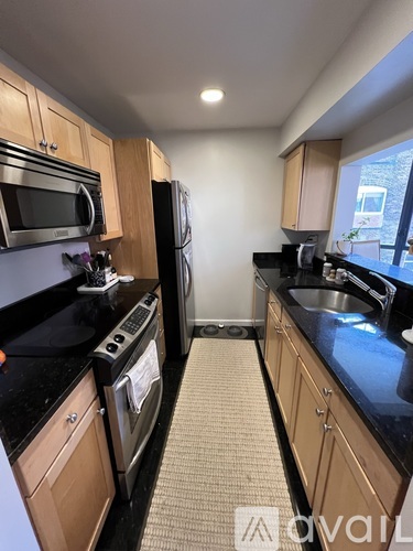 A kitchen with wooden cabinets and black countertops.