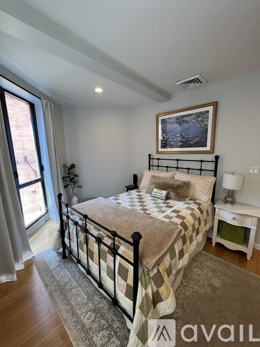 A bedroom with a large bed and a painting on the wall.