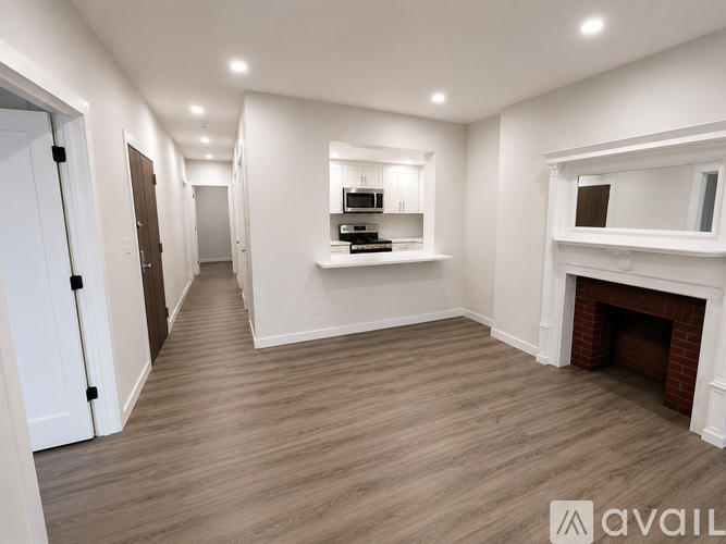 A spacious room with a fireplace and a mirror on the wall.