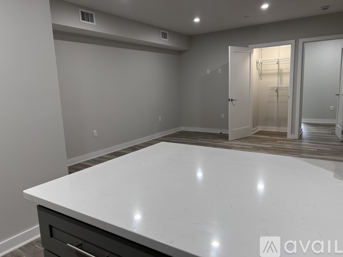 A spacious kitchen with a white countertop and a walk-in pantry.