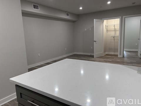 A spacious kitchen with a white countertop and a walk-in pantry.