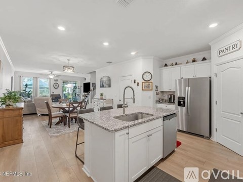 A kitchen with a dining table and chairs in the middle of the room.