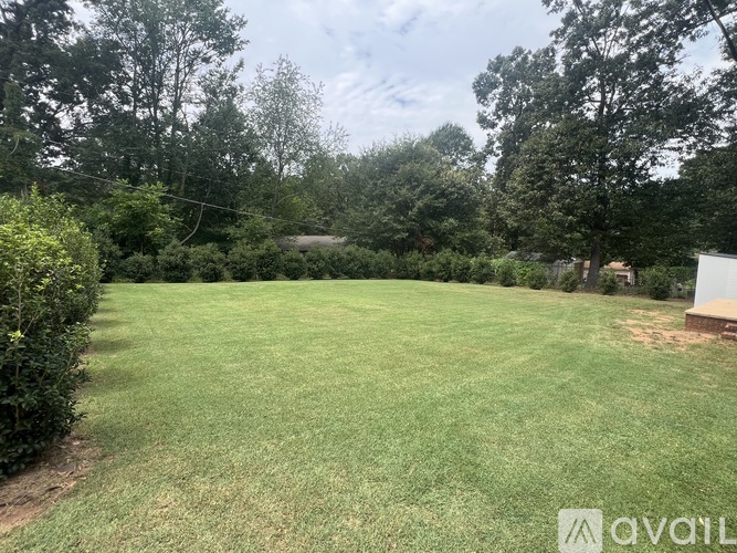 A backyard with a well-maintained lawn and trees.