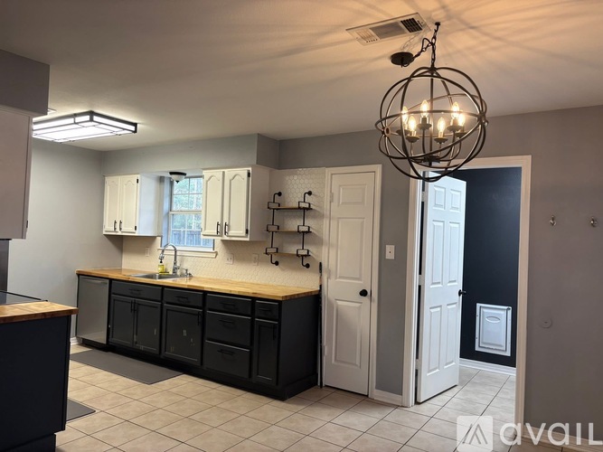 A kitchen with black cabinets and a wooden island.
