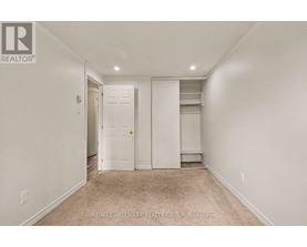 A white bedroom with a door and a window.