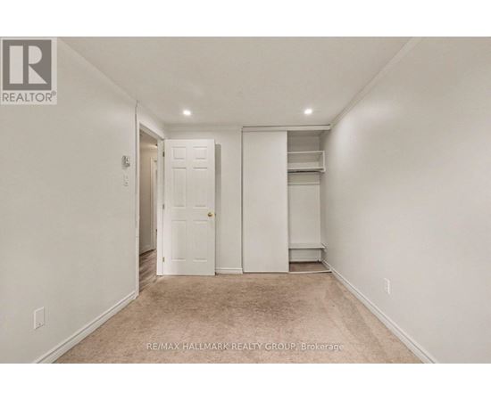 A white bedroom with a door and a window.