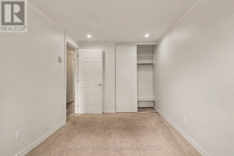 A white bedroom with a door and a window.