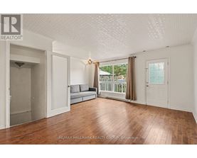 A spacious room with wooden flooring and white walls.