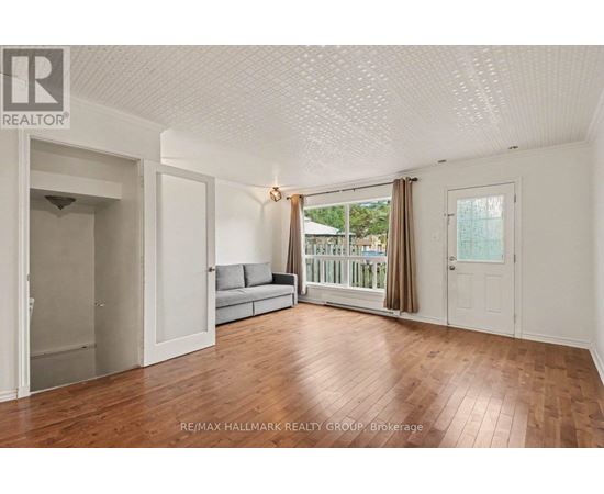 A spacious room with wooden flooring and white walls.