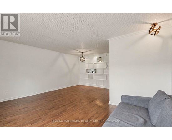A living room with a grey couch and a wooden floor.