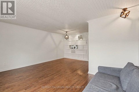 A living room with a grey couch and a wooden floor.