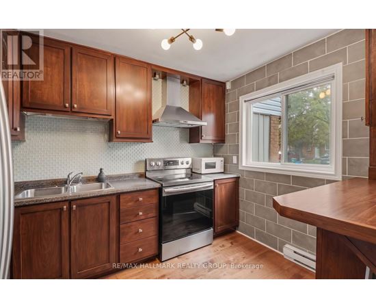 A kitchen with wooden cabinets and a brick wall.