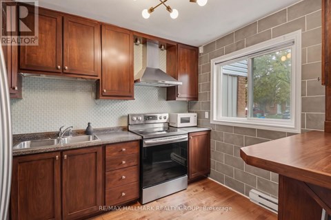 A kitchen with wooden cabinets and a brick wall.