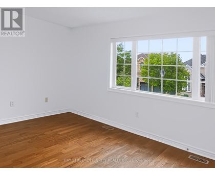 A room with a window showing a view of houses and trees outside.