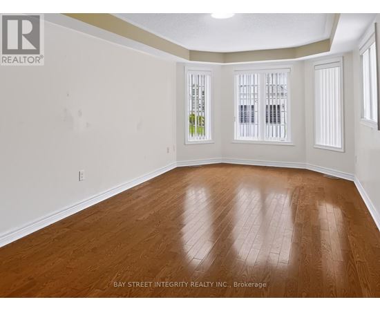 A room with wooden flooring and white walls.
