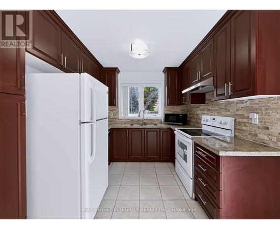 A kitchen with brown cabinets and a white refrigerator.