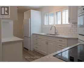 A kitchen with white appliances and cabinets.