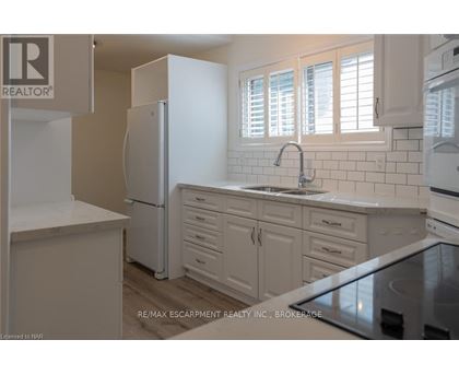 A kitchen with white appliances and cabinets.
