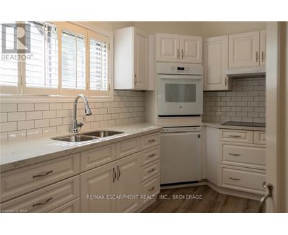 A kitchen with white cabinets and a white oven.